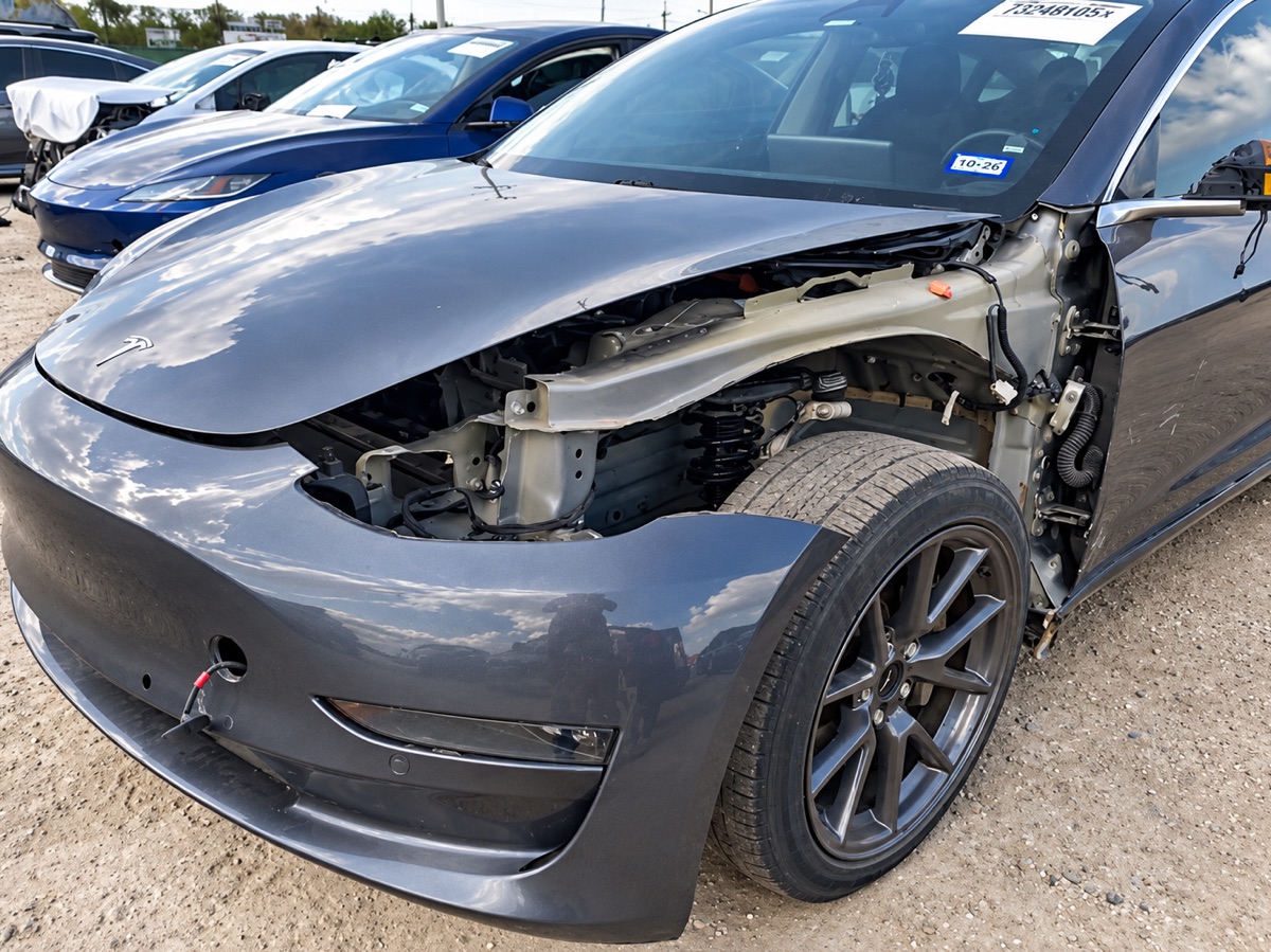 Before: a gray Tesla Model 3 with its front fender and bumper damaged in a collision